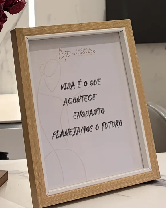 Quadro de moldura de madeira sobre o balcão, com a frase escrita à mão